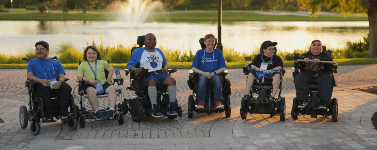 Boys in their wheelchairs hanging out by the pond. 